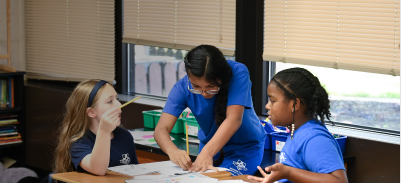 Image of students sitting in a classroom while a teacher is teaching.  Image by Kenny Eliason on Unsplash.